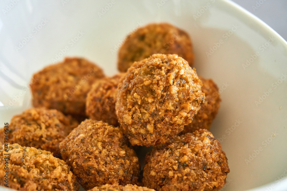 Close-up of fresh and crispy falafels balls inside a white bowl, authentic deep fried chickpea hot round falafels Close-up of fresh and crispy falafels balls inside a white bowl, authentic deep fried chickpea hot round falafels
