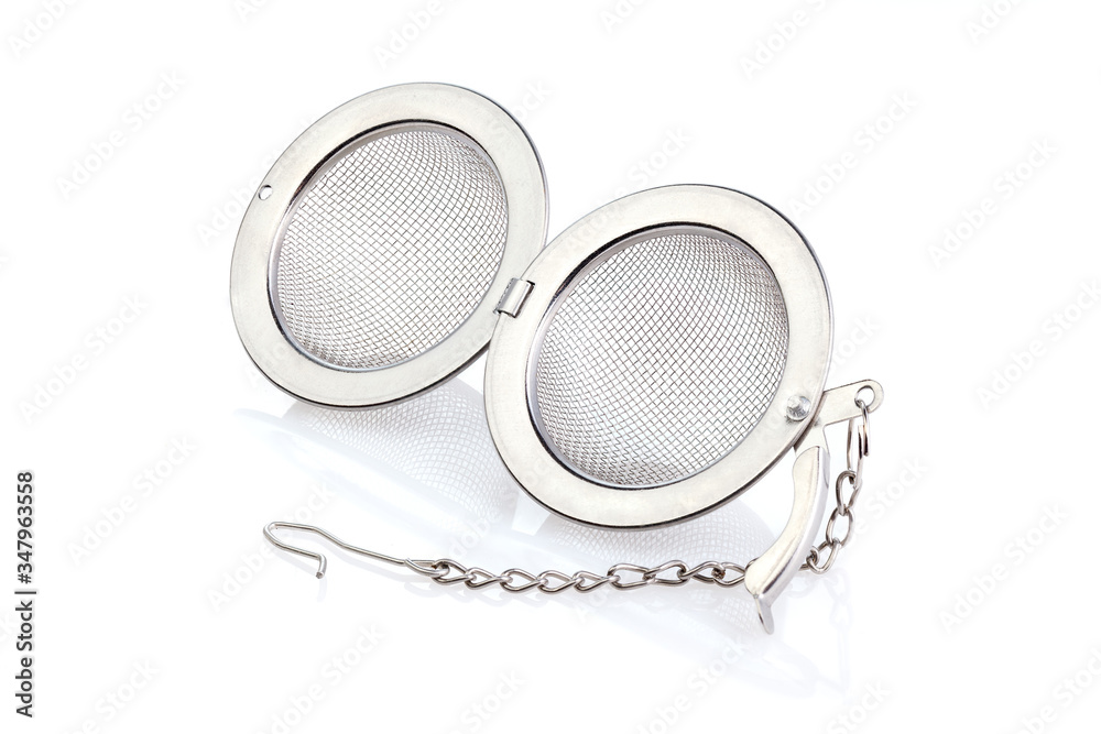 Tea strainer on a chain isolated for white background. A tea strainer is a kitchen accessory close-up. Full depth of field. Tea strainer on a chain isolated for white background. A tea strainer is a kitchen accessory close-up. Full depth of field.