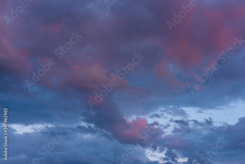 Cloudy sunset sky. Lilac light on a blue cloudy sky.