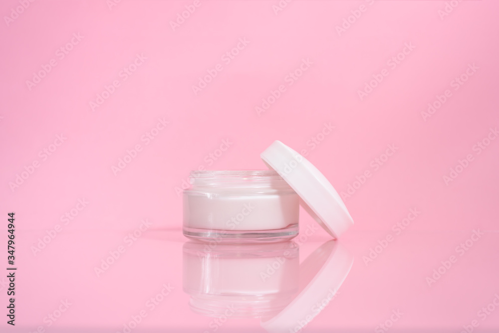 Opened jar of facial cream on the pink background. Opened jar of facial cream on the pink background.
