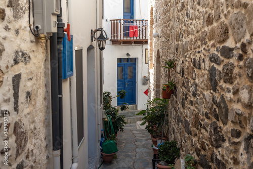 Narrow street in old town. Beautiful street with white buildings in Mandrakion Greece. photo