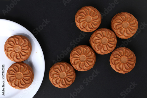 Plate with brown cookies on old Black Stone table. Top view