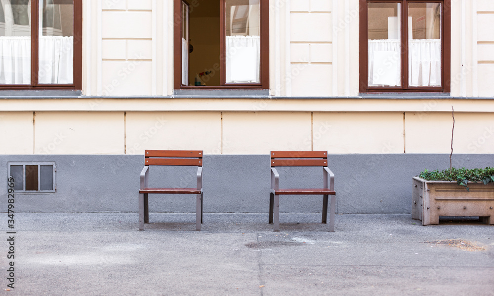 Social distancing in public area. Soziale Distanz im öffentlichen Raum. Zwei leere Sessel mit Abstand. Two lonely chairs in the street. Social distancing in public area. Soziale Distanz im öffentlichen Raum. Zwei leere Sessel mit Abstand. Two lonely chairs in the street.