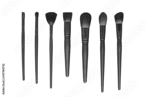 Collection of black makeup brushes isolated on white background. Flat lay. Top view