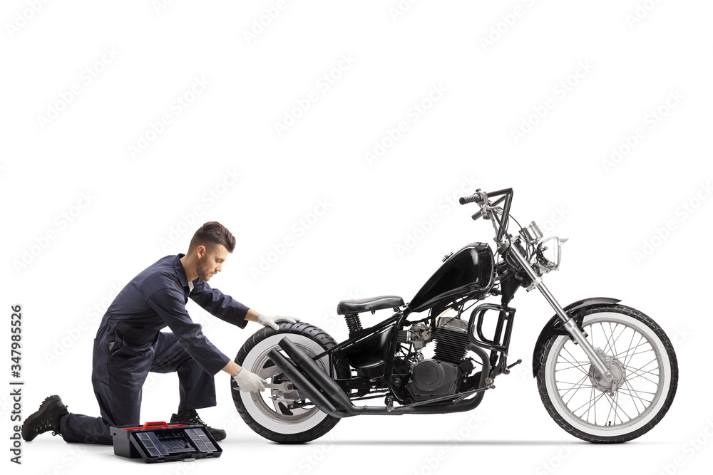 Motorcycle mechanic repairing a chopper motorbike Motorcycle mechanic repairing a chopper motorbike
