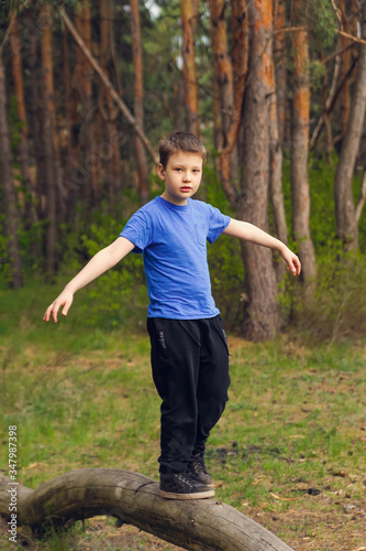 boy walks on a log and learns to keep balance