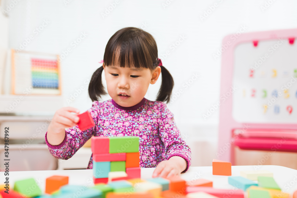 toddler girl playing creative toy blocks at home against white background toddler girl playing creative toy blocks at home against white background