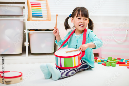 toddler girl play drum at home for homeschooling