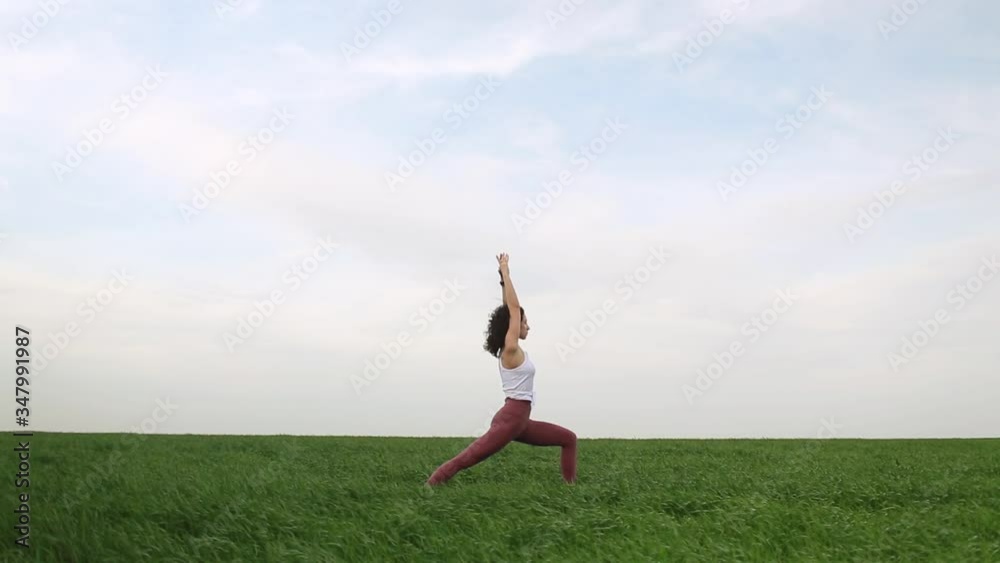 Young slim girl doing yoga outdoors in a green field Young slim girl doing yoga outdoors in a green field
