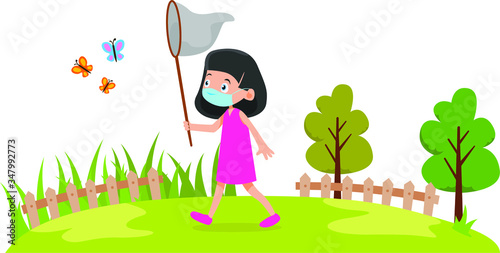 A girl catching a butterfly on the field while using medical mask
