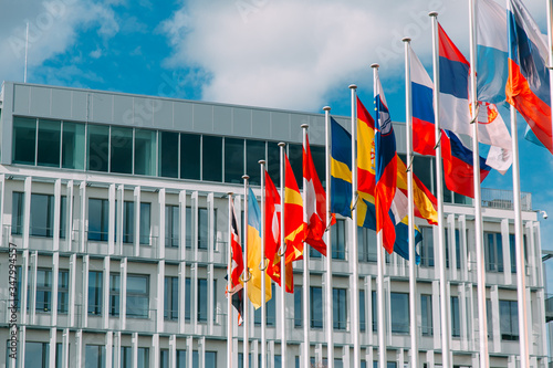 flags of European countries developing on flagpoles near the building photo