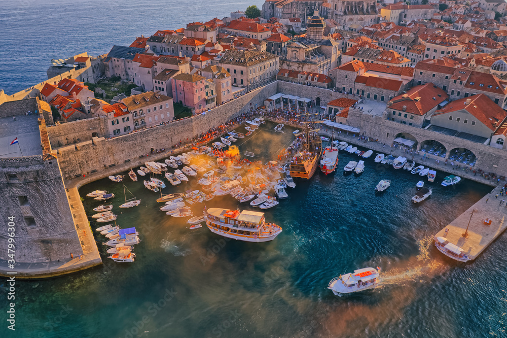 DUBROVNIK, CROATIA - AUGUST 28 2019: Wild league water polo finals in the old town harbor with a view of the Porporela breakwater and St Ivan fortress. Aerial drone panorama shot.