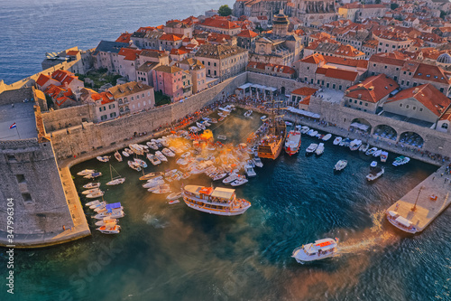 DUBROVNIK, CROATIA - AUGUST 28 2019: Wild league water polo finals in the old town harbor with a view of the Porporela breakwater and St Ivan fortress. Aerial drone panorama shot.