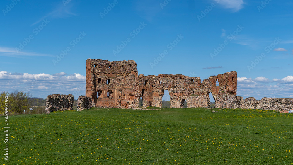 Ludza Medieval Castle Ruins on a Hill Between Big Ludza Lake and Small Ludza Lake. The Ruins of an Ancient Castle in Latvia. Sunny Spring Day.