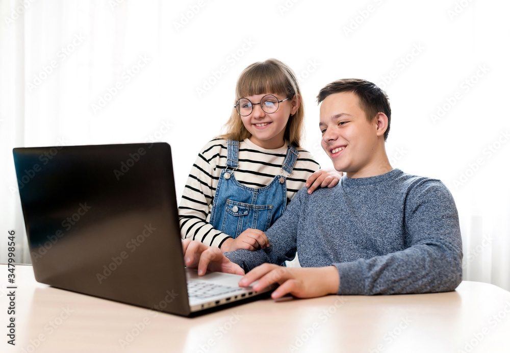Smiling children with a tablet computer. Family, brother and sister, technology and home concept. Remote communication on the Internet, online education