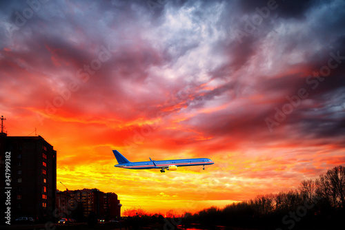 Big aeroplane is taking-off on background of sunset.