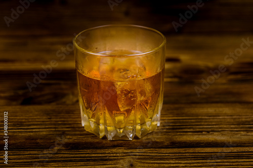 Glass of whiskey on the dark wooden background
