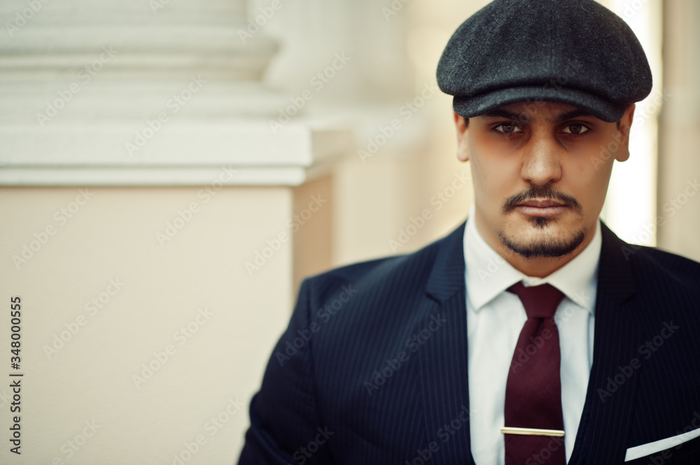 Portrait of retro 1920s english arabian business man wearing dark suit, tie and flat cap. Portrait of retro 1920s english arabian business man wearing dark suit, tie and flat cap.