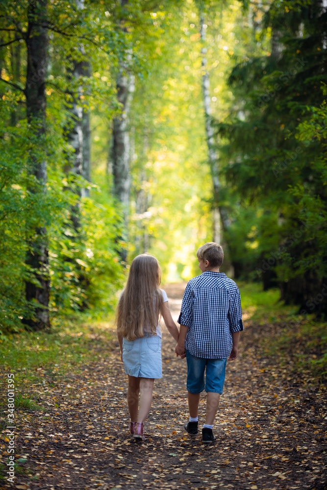 Brother and sister play, laugh, fool around and make grimaces and funny faces together. Little boy and girl, friends, children, kids smile and have fun. Family weekend outdoors.