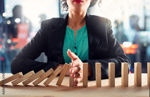 Canvas Print Businesswoman stops a chain fall like domino game