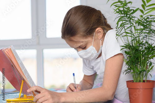 Fotografie A sick girl teaches homework and does homework