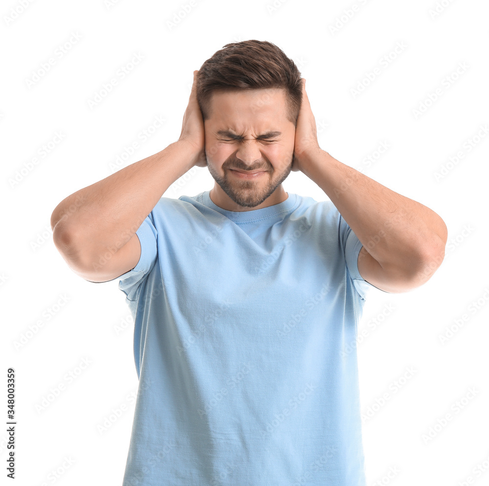 Young man suffering from loud noise on white background Young man suffering from loud noise on white background