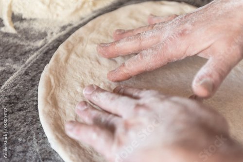 Stendere l'impasto della pizza con le mani con metodo artiginale