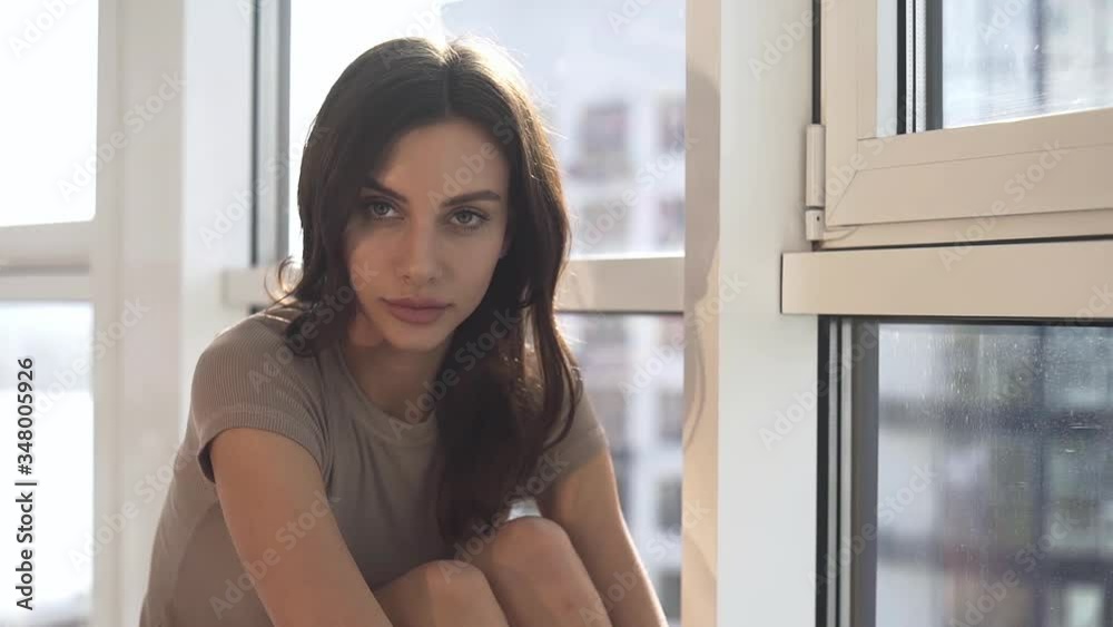 A sexy model poses at sunset in her apartment with panoramic windows. emotion evening mood calm, outside the city and the Dnieper river. A sexy model poses at sunset in her apartment with panoramic windows. emotion evening mood calm, outside the city and the Dnieper river.