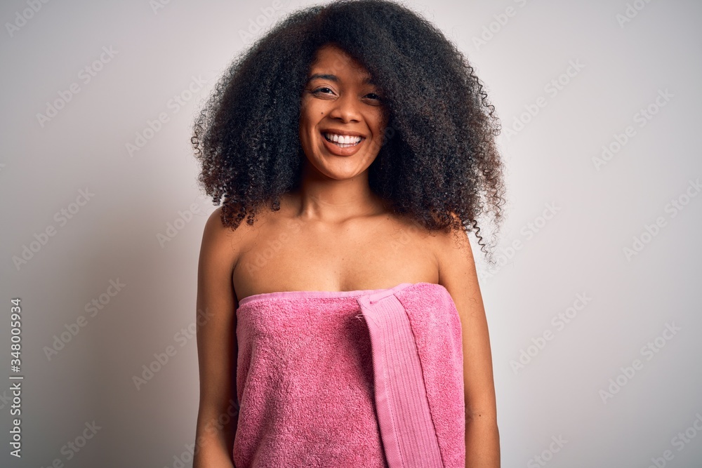 Young african american woman with afro hair wearing a body towel after beauty care shower with a happy and cool smile on face. Lucky person. Young african american woman with afro hair wearing a body towel after beauty care shower with a happy and cool smile on face. Lucky person.