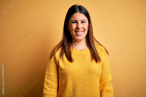 Young beautiful woman wearing casual sweater over yellow isolated background with a happy and cool smile on face. Lucky person. © Krakenimages.com