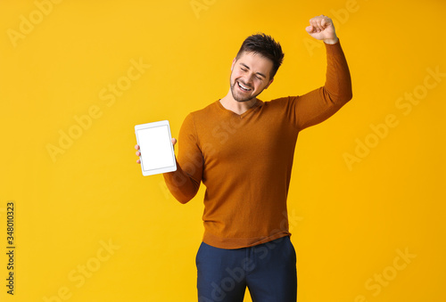 Happy young man with tablet...