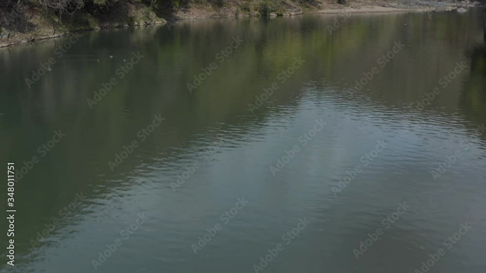 Peaceful Katsura river in Arashiyama. Low Aerial tilt over Kyoto Valley Peaceful Katsura river in Arashiyama. Low Aerial tilt over Kyoto Valley