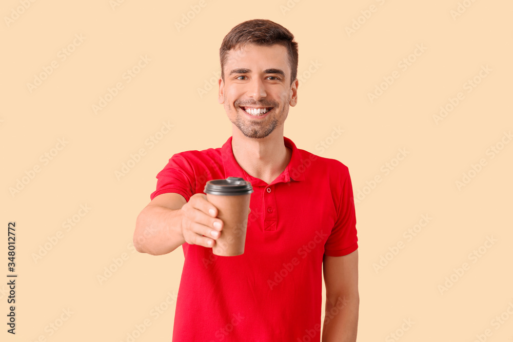 Young man with cup of hot coffee on color background Young man with cup of hot coffee on color background
