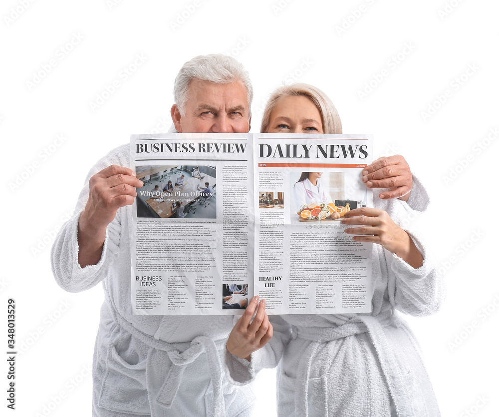 Mature couple in bathrobes and with newspaper on white background Mature couple in bathrobes and with newspaper on white background