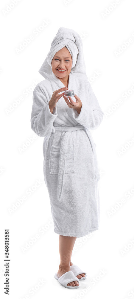 Mature woman in bathrobe and with jar of cream on white background Mature woman in bathrobe and with jar of cream on white background