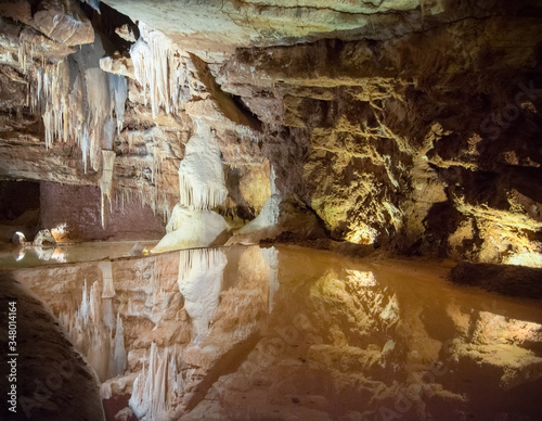 Stalactites et stalagmites dans une cavité souterraine avec un miroir d'eau photo