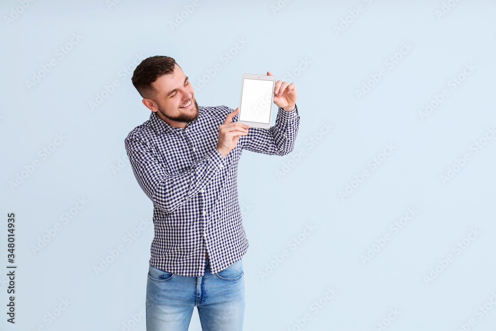Young man with tablet computer on color background Young man with tablet computer on color background