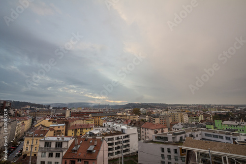 Aerial panorama of Brno, Czech Republic, with a focus on a residential suburb with panelaky towers in background, from the roofs of houses. Brno is the second biggest Czech city