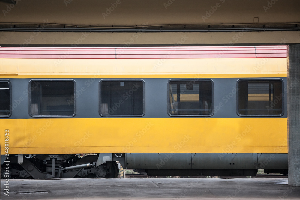 Fototapeta premium Passenger car abiding by European standards on standby, empty, in a typical platform of a train station in Europe. Railway travel is one of the biggest transportation mode in Europe.