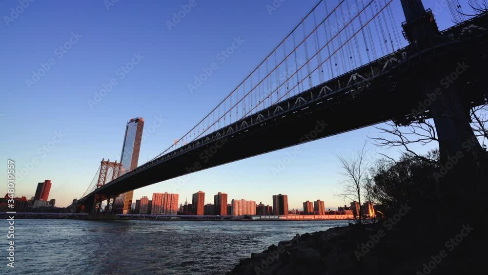 Manhattan bridge with lower Manhattan skyline in the morning with colorful light over East River in New York City Manhattan bridge with lower Manhattan skyline in the morning with colorful light over East River in New York City