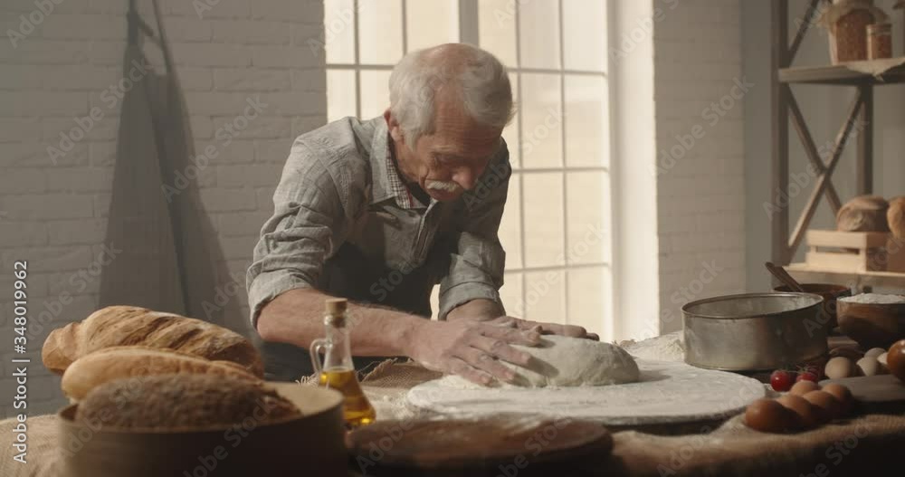 Professional senior moustached caucasian baker forming a bread loaf out of dough with passion, elderly pensioneer enjoying his hobby after retirement 4k footage Professional senior moustached caucasian baker forming a bread loaf out of dough with passion, elderly pensioneer enjoying his hobby after retirement 4k footage