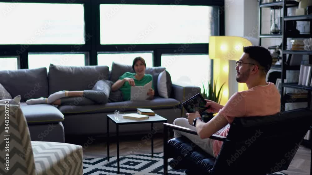 Young husband updating app for playing game on touch pad using wireless internet connection while attractive wife lying on comfortable couch in modern apartment with stylish interior
Young husband updating app for playing game on touch pad using wireless internet connection while attractive wife lying on comfortable couch in modern apartment with stylish interior