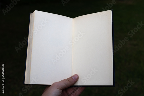 White open notebook held by hand. POV.