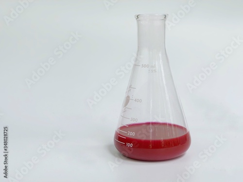 Red solution in Erlenmeyer flask used for chemistry analysis in laboratory, isolated on white background