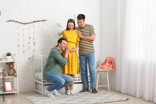 Gay couple with pregnant woman at home © Pixel-Shot