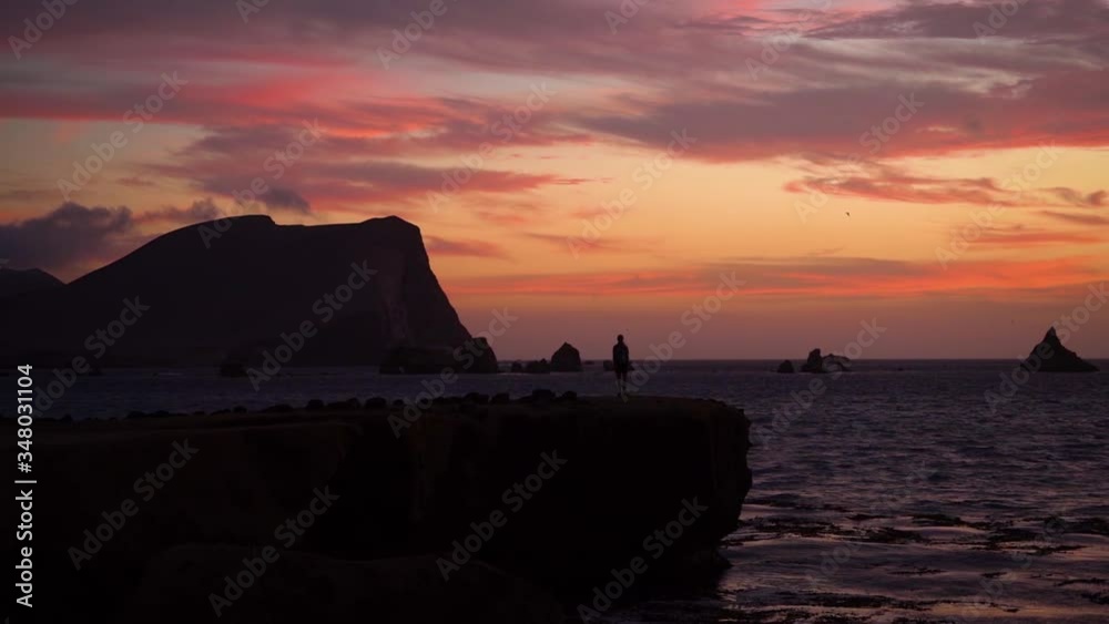Silhouette landscape during dramatic colorful sunset at Peruvian coast, slowmo