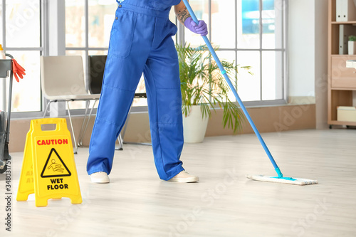 Male janitor mopping floor ...