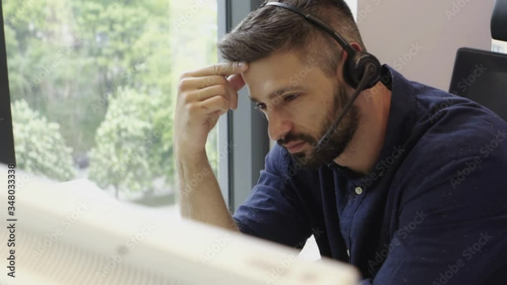 Bearded Attractive Businessman working in call center office using headset
Bearded Attractive Businessman working in call center office using headset