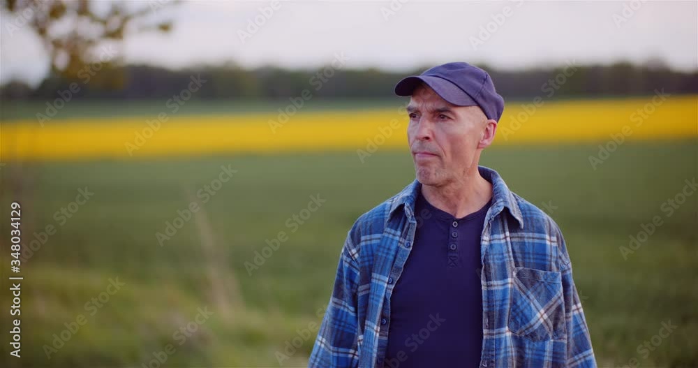 Positive Adult Farmer Smiling into Camera at Field - Agriculture. Positive Adult Farmer Smiling into Camera at Field - Agriculture.