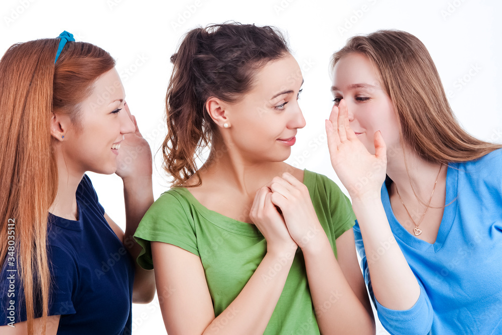 Gossips and Rumors Ideas. Three Young caucasian Girlfriends Sharing Their Secrets Whispering to Ears. Over White Background Gossips and Rumors Ideas. Three Young caucasian Girlfriends Sharing Their Secrets Whispering to Ears. Over White Background